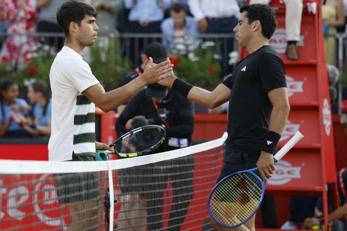 Alcaraz (trái) bắt tay Munar trong trận vòng hai Queens Club Championships, tại London, Anh hôm 19/6. Ảnh: Reuters